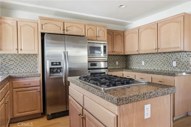 a kitchen with granite countertop a sink stove and refrigerator