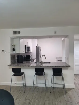 a room with a stove and white cabinets