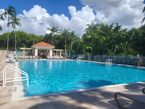 a view of backyard with swimming pool and seating area