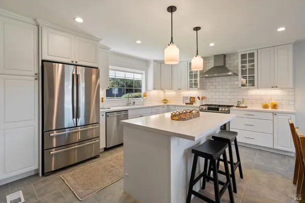 a kitchen with refrigerator a stove and a kitchen island
