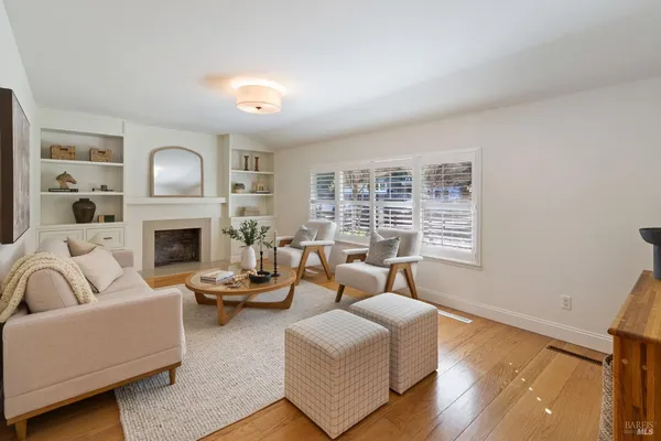 a living room with furniture a fireplace and a large window