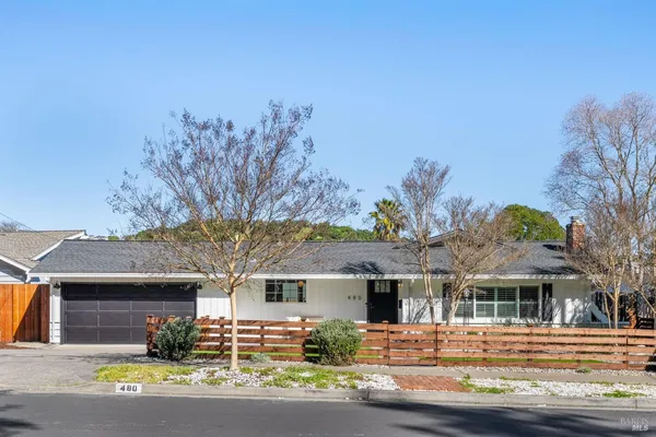 a front view of a house with a yard garage and outdoor seating
