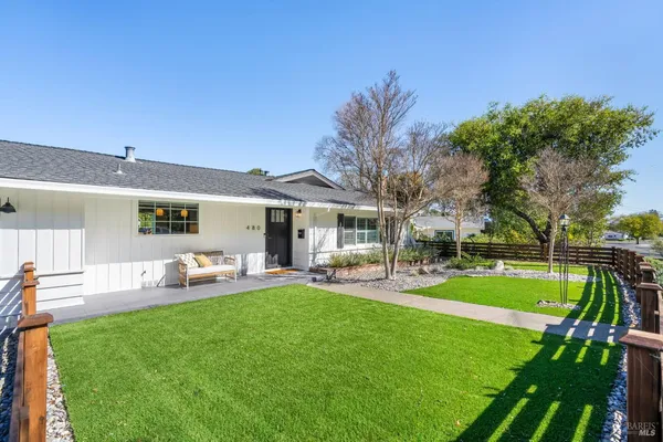 a view of a house with backyard and sitting area