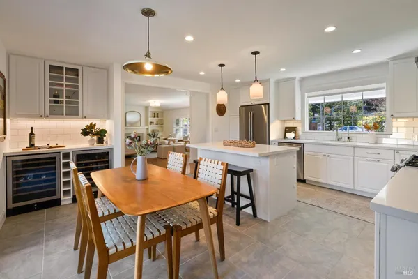 a kitchen with a dining table chairs sink and cabinets