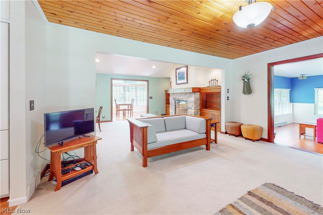 86532 North Bay Road Scio, OH 43988 - Photo 7 of 48 Spacious interior featuring a wood-panel ceiling, light-colored carpeting, recessed lighting, and a stone fireplace surround with built-in wooden shelving