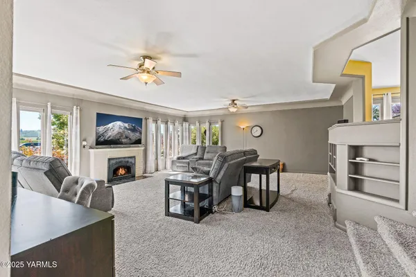 a living room with furniture a fireplace and a flat screen tv