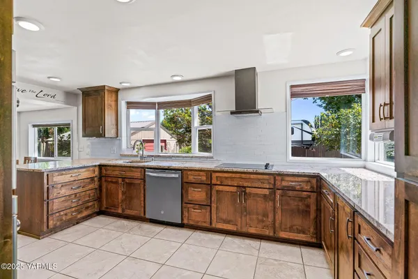 a kitchen with stainless steel appliances granite countertop a refrigerator and a stove top oven