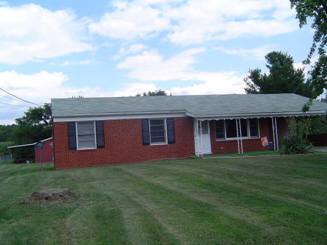 7464 Spring Creek Road Bridgewater, VA 22812 - Photo 1 of 9 a view of a yard in front of a house with plants and large tree