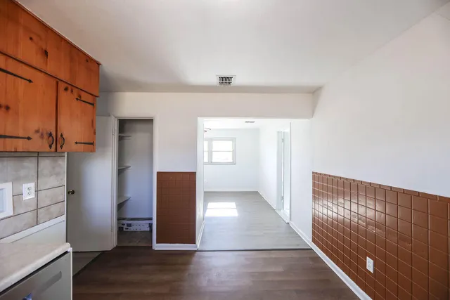 wooden floor in an empty room with a kitchen
