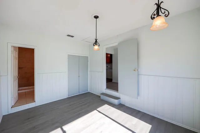 a view of a livingroom with wooden floor and a ceiling fan