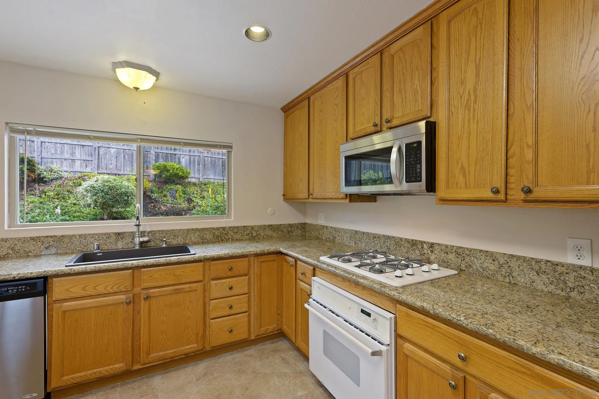 12443 McFeron Road Poway, CA 92064 - Photo 15 of 37 a kitchen with granite countertop cabinets stainless steel appliances a sink and a window