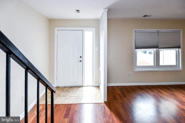 a view of front door with wooden floor and stairs
