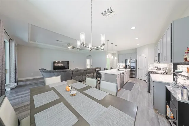 a living room with lots of furniture hardwood floor and a kitchen view