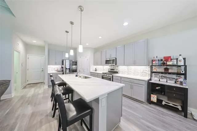 a kitchen with kitchen island a stove a table and chairs in it