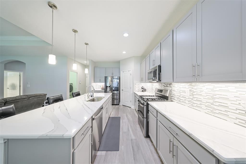 130 Azul Drive Seffner, FL 33584 - Photo 18 of 47 a kitchen with stainless steel appliances kitchen island granite countertop a sink a stove and a wooden floors