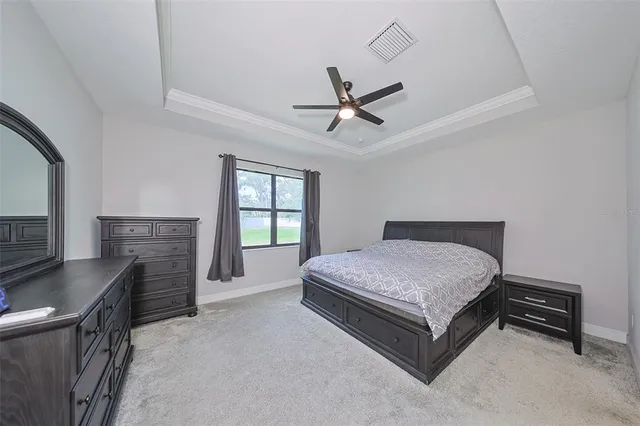 a spacious bedroom with a bed and a flat screen tv