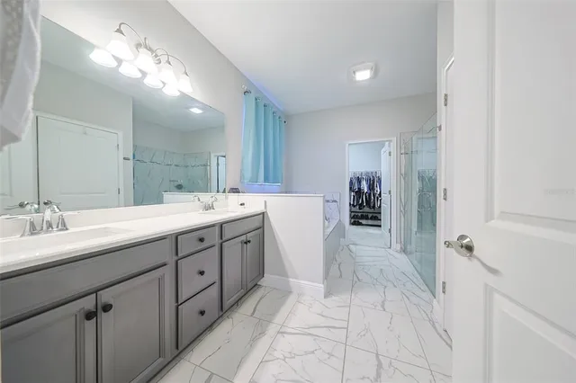 a spacious bathroom with a double vanity sink a mirror and shower