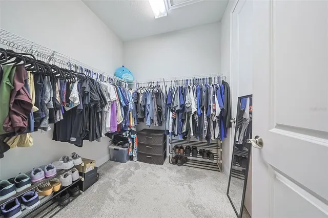 a view of walk in closet with clothes
