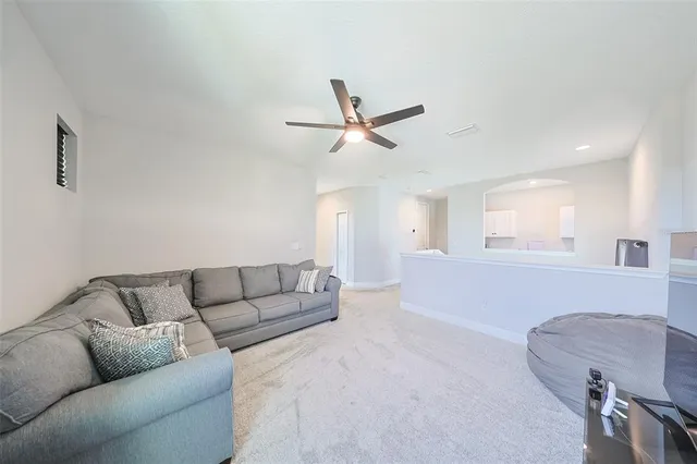 a living room with furniture and a ceiling fan