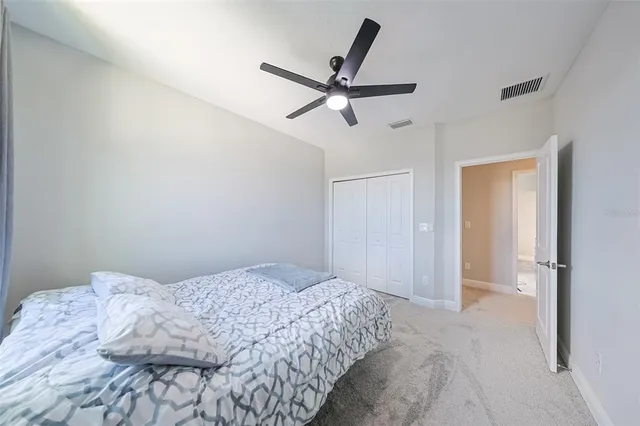 an empty room with windows flat screen tv and ceiling fan