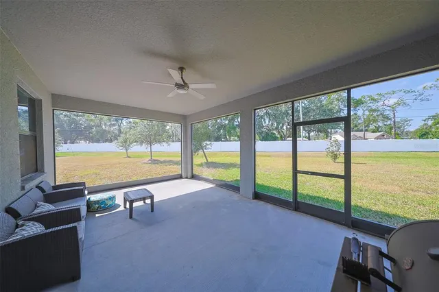 a living room with furniture floor to ceiling window and an outdoor view