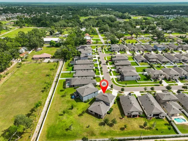 an aerial view of residential houses with outdoor space and swimming pool
