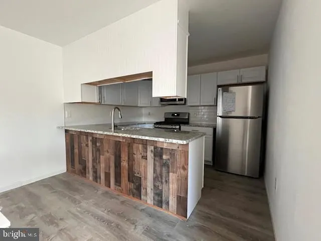 a kitchen with stainless steel appliances granite countertop a refrigerator sink and cabinets
