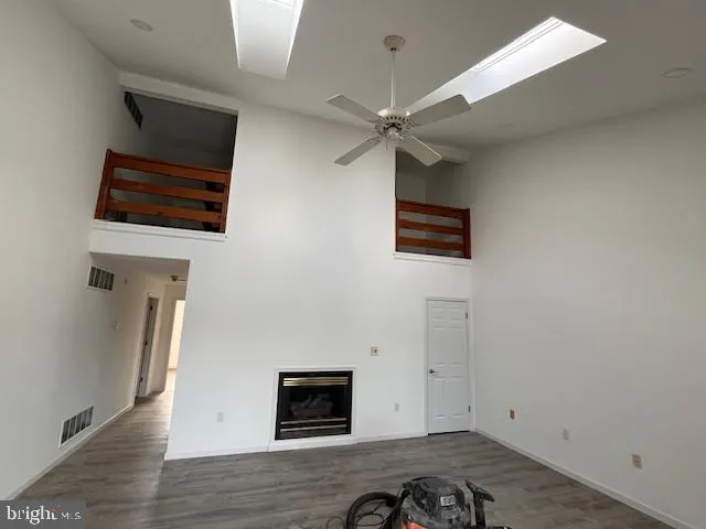 an empty room with wooden floor ceiling fan