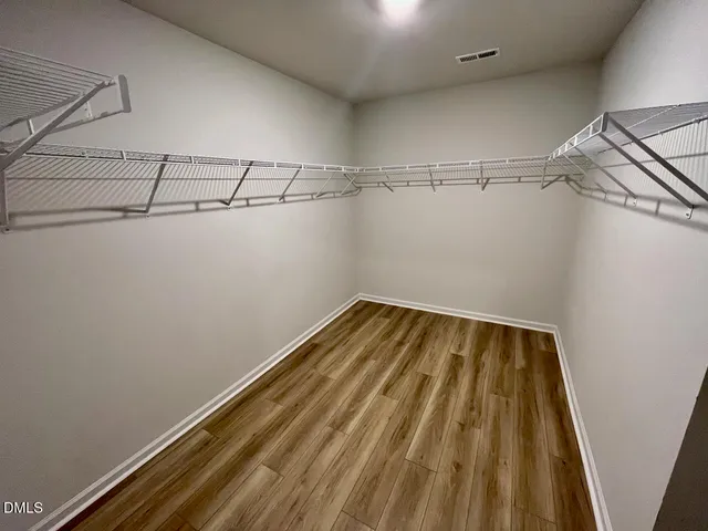 a view of a hallway with entryway wooden floor and cabinet