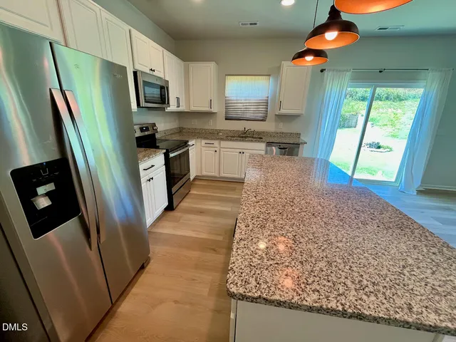 a kitchen with stainless steel appliances granite countertop a refrigerator and a sink