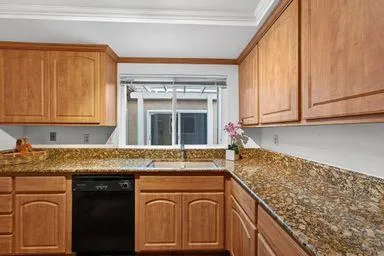 a kitchen with granite countertop cabinets sink and window