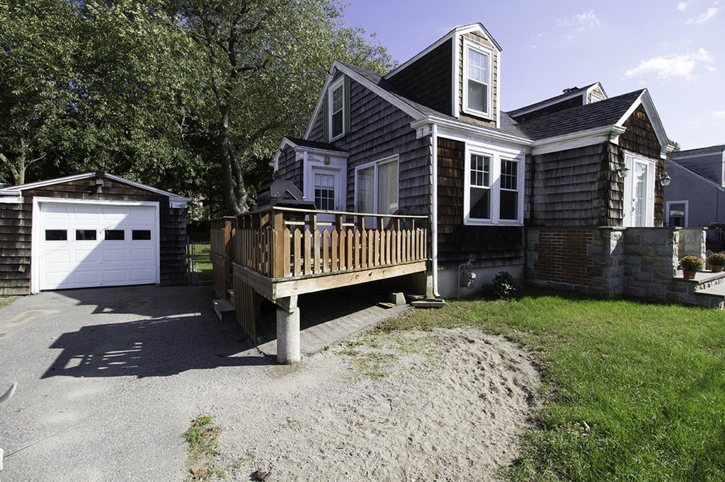 a front view of a house with yard and parking