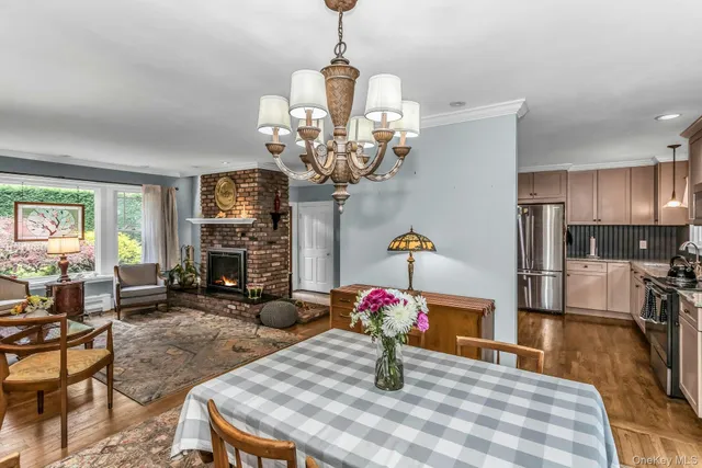 a dining room with wooden floor a chandelier a wooden table and chairs