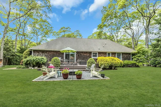 a front view of a house with a garden and trees
