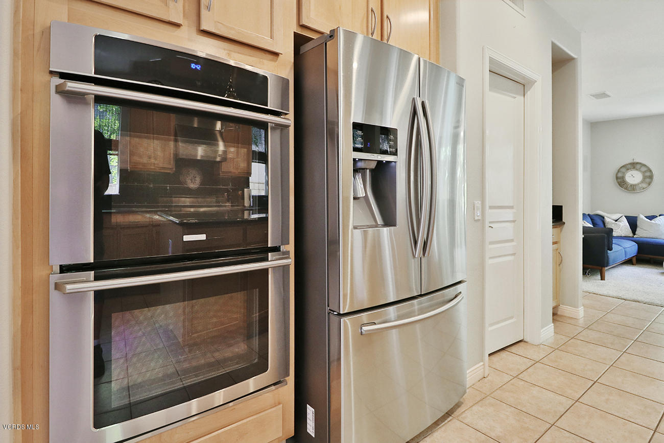 143 Brooks Road Simi Valley, CA 93065 - Photo 16 of 42 a metallic refrigerator freezer and a stove sitting inside of a kitchen