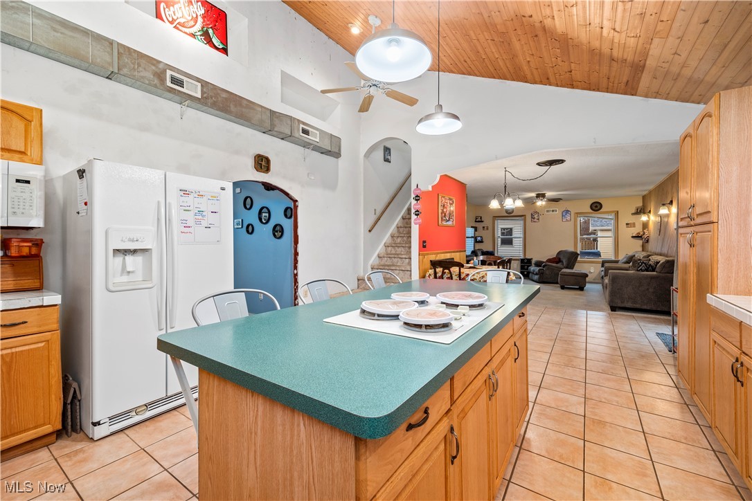5569 Lear Nagle Road North Ridgeville, OH 44039 - Photo 11 of 41 Kitchen with high vaulted ceiling, light tile patterned floors, white appliances, and a kitchen island
