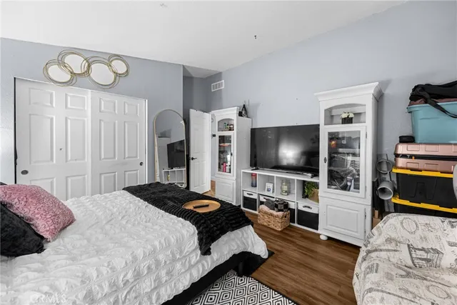 a bedroom with a bed and a flat tv screen on wall