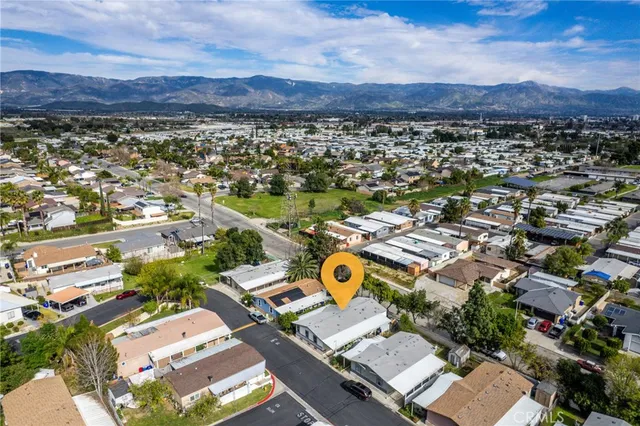 an aerial view of residential house with yard and mountain view in back