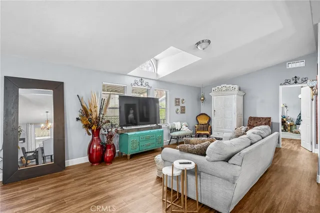 a living room with furniture a flat screen tv and a window