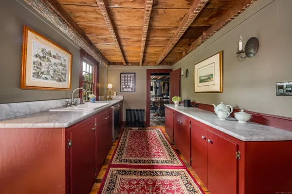 a large kitchen with kitchen island granite countertop a sink dishwasher a refrigerator and wooden cabinets