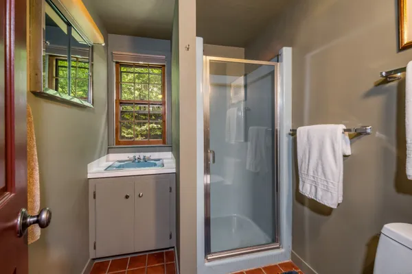 a bathroom with a granite countertop sink toilet and shower
