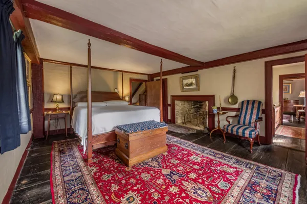 a spacious bedroom with a bed a mirror and a large window