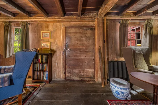 a view of a hallway with furniture and wooden floor