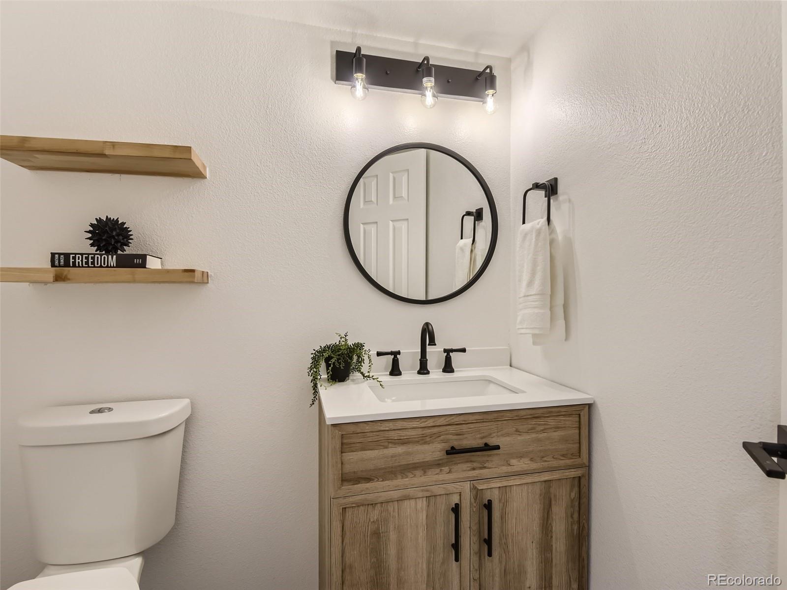 6222 Yale Drive Highlands Ranch, CO 80130 - Photo 12 of 32 a bathroom with a toilet a sink and a mirror