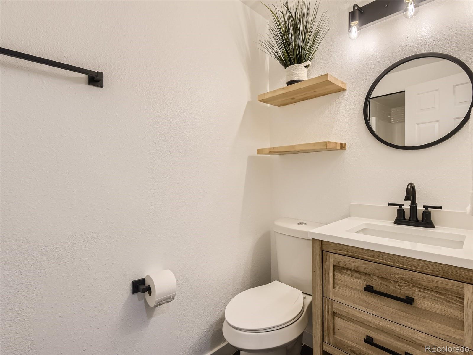 6222 Yale Drive Highlands Ranch, CO 80130 - Photo 21 of 32 a bathroom with a toilet a sink and mirror