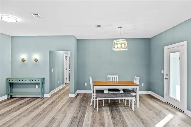 a kitchen with stainless steel appliances kitchen island granite countertop a refrigerator a stove a sink dishwasher and a oven with white cabinets