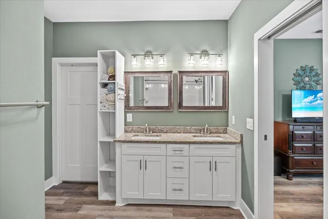 a bathroom with a granite countertop sink and a mirror