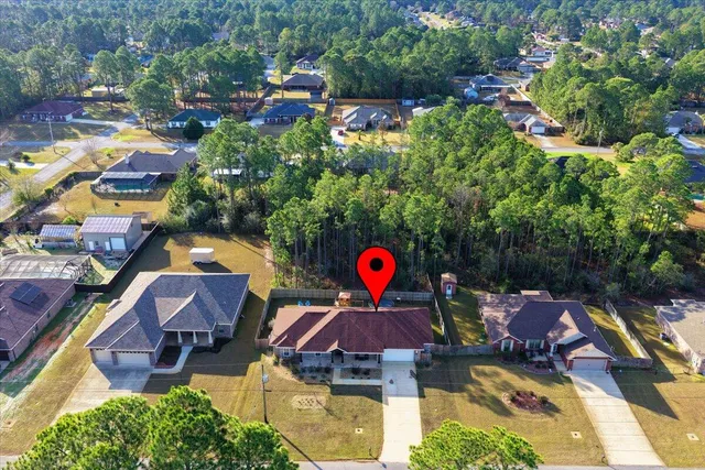 an aerial view of a house with yard and swimming pool