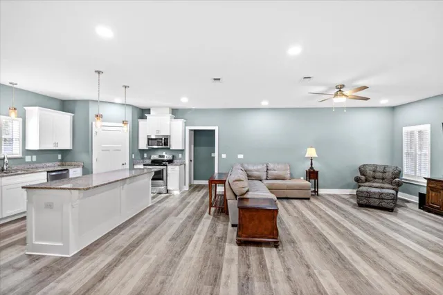 a living room with stainless steel appliances kitchen island granite countertop furniture and a kitchen view