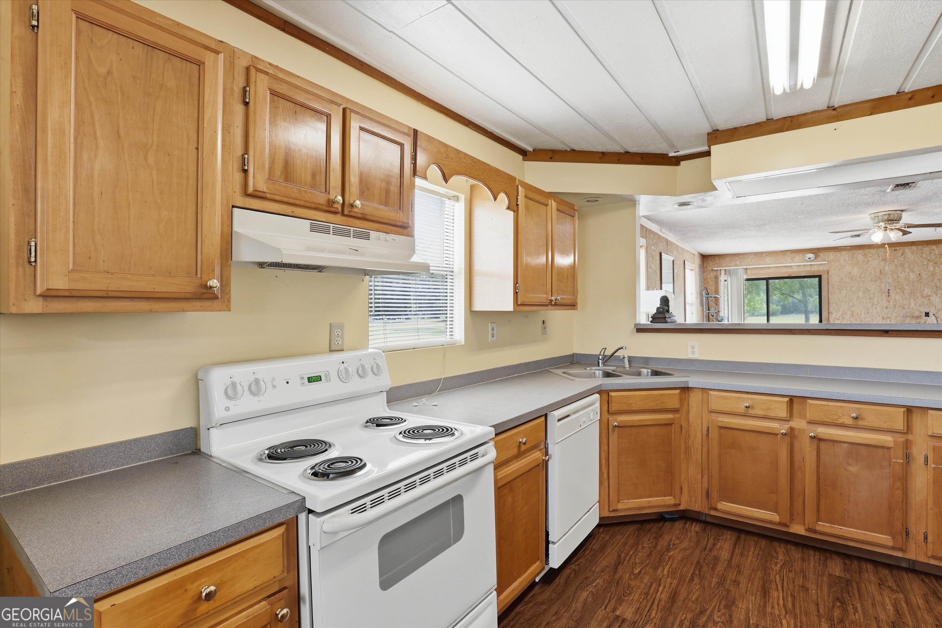 1525 Myron Hart Road Coolidge, GA 31738 - Photo 14 of 58 a kitchen with a sink a stove cabinets and wooden floor